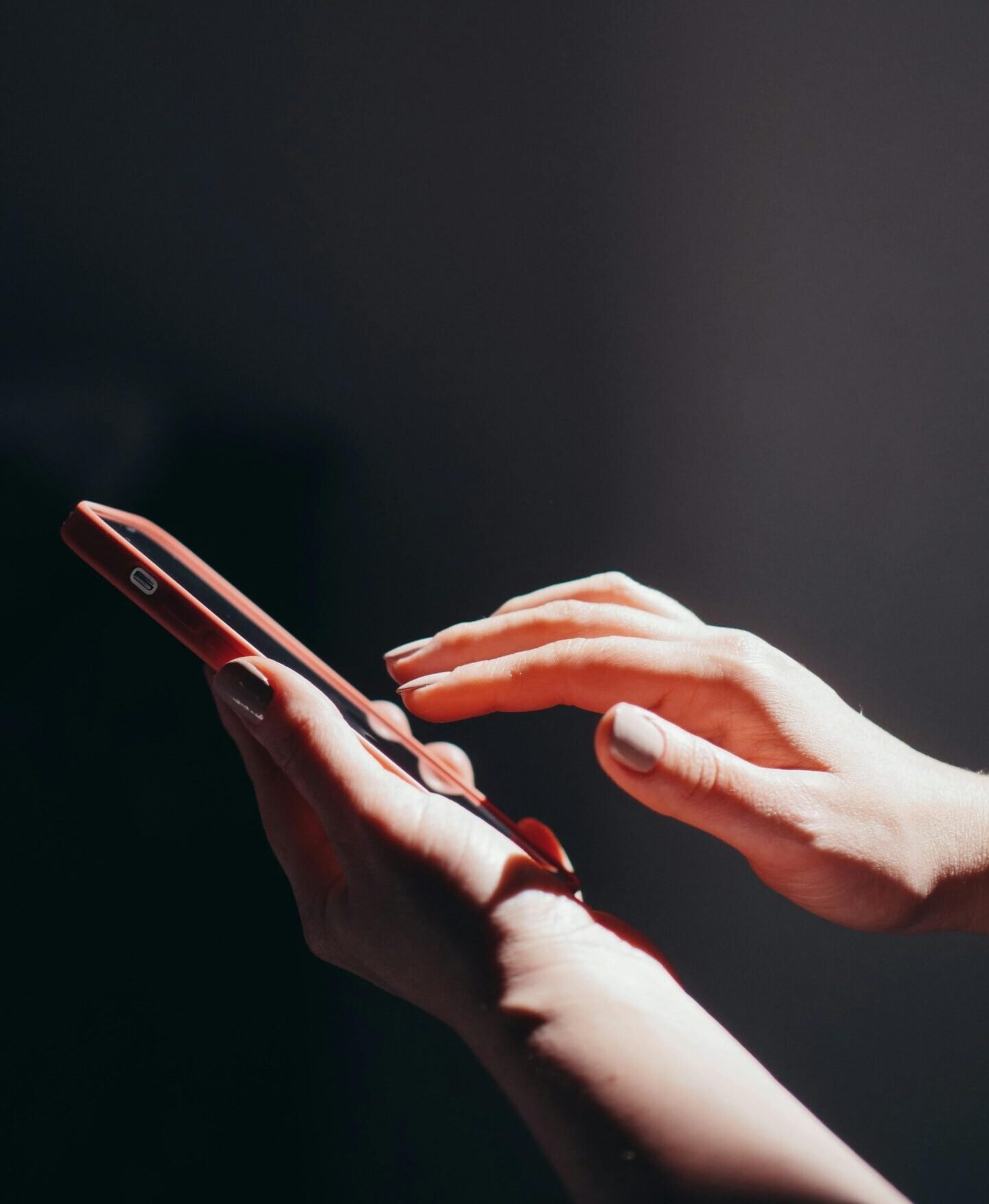 Hands interacting with a smartphone in a well-lit setting, emphasizing connection and technology.